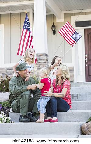 Stock Photo - Caucasian soldier and family playing together on front stoop. Fotosearch