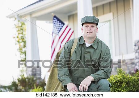 Stock Photography - Caucasian soldier kneeling near house. Fotosearch