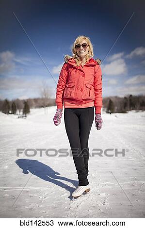 Stock Image - Caucasian woman on ice skates on frozen lake. Fotosearch