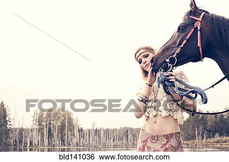 Caucasian woman petting horse near lake View Large Photo Image Stock Photograph - Caucasian woman petting horse near lake. Fotosearch