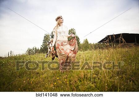Caucasian woman walking in field View Large Photo Image Stock Photo - Caucasian woman walking in field. Fotosearch