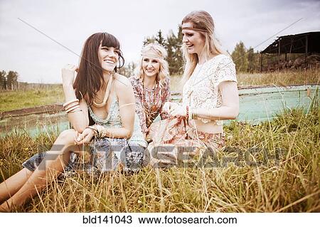 Stock Image - Caucasian women laughing in field. Fotosearch