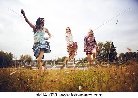 Stock Photo - Caucasian women playing in field near lake. Fotosearch