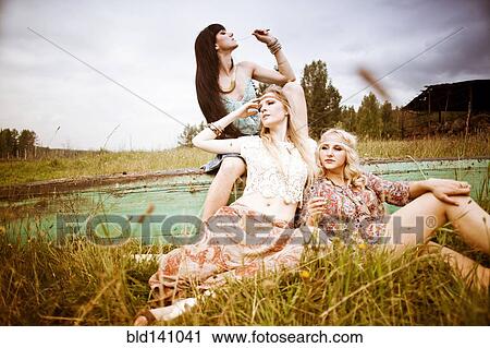 Stock Image - Caucasian women relaxing in field. Fotosearch