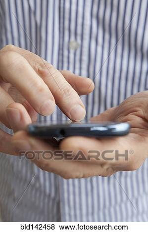 Stock Photo - Close up of Hispanic senior man using cell phone. Fotosearch