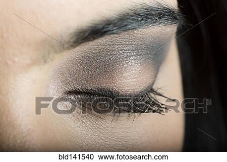 Stock Image - Close up of makeup on eyelid of Hispanic woman. Fotosearch