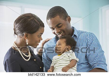 Stock Image - Couple cradling baby son. Fotosearch