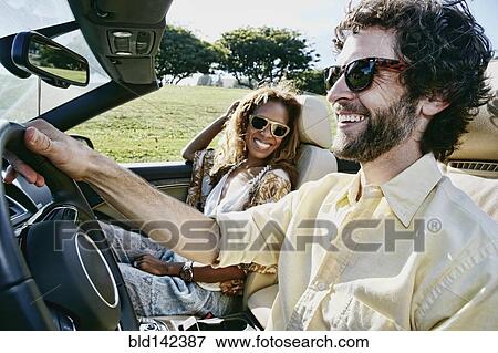 Stock Photo - Couple driving together in convertible. Fotosearch