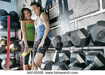Stock Photograph - Couple smiling together in gym. Fotosearch