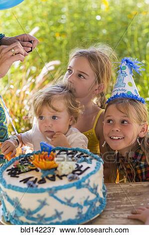 Stock Photo - Family celebrating birthday together outdoors. Fotosearch