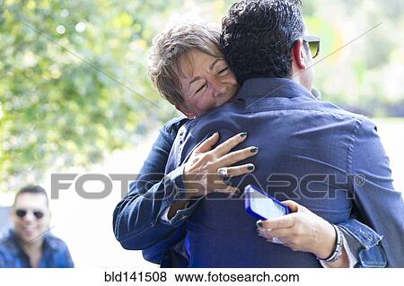 Stock Photo - Family members hugging at reunion. Fotosearch