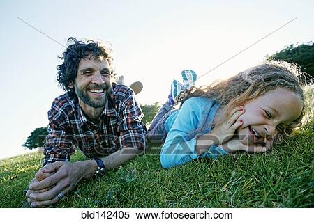 Father and daughter playing in grassy field View Large Photo Image Stock Photography - Father and daughter playing in grassy field. Fotosearch