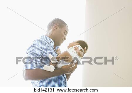 Father cradling baby son View Large Photo Image Stock Image - Father cradling baby son. Fotosearch