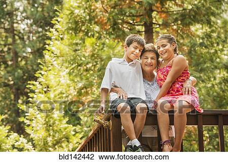 Stock Image - Grandmother and grandchildren smiling on banister. Fotosearch