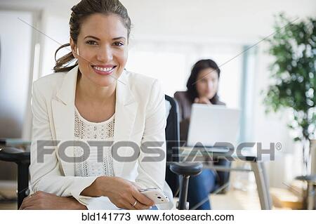 Hispanic businesswoman smiling in office View Large Photo Image Stock Image - Hispanic businesswoman smiling in office. Fotosearch