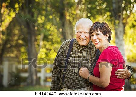 Stock Image - Hispanic father and daughter hugging outdoors. Fotosearch