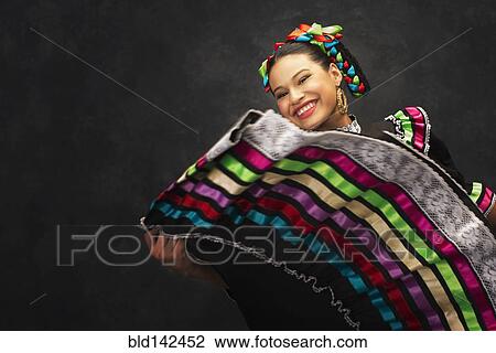 Stock Image - Hispanic teenage girl dancing in Jallisco Folkloric dress. Fotosearch