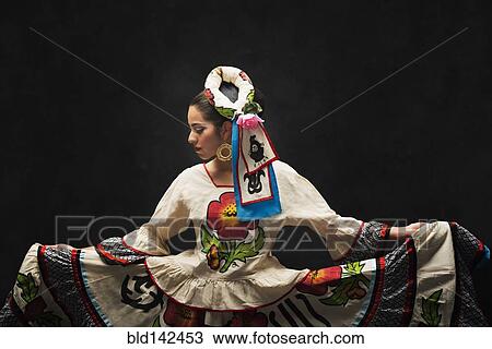 Stock Image - Hispanic teenage girl dancing in Sinaloa Folkloric dress. Fotosearch