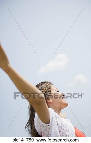 Stock Photo - Hispanic woman playing under blue sky. Fotosearch