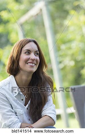 Picture - Hispanic woman smiling outdoors. Fotosearch