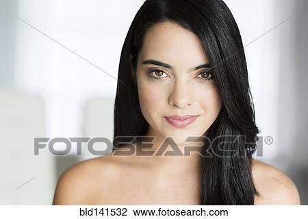 Stock Image - Hispanic woman with long hair smiling. Fotosearch