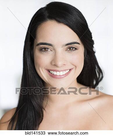 Stock Image - Hispanic woman with long hair smiling. Fotosearch