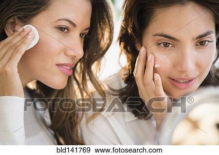 Hispanic women applying makeup in mirror View Large Photo Image Stock Photo - Hispanic women applying makeup in mirror. Fotosearch