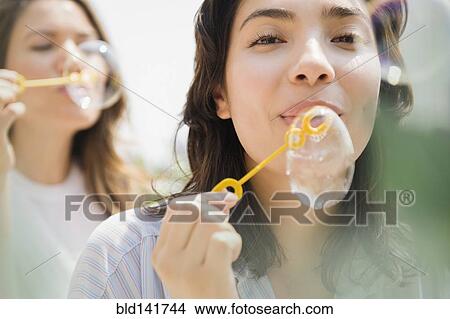 Hispanic women blowing bubbles outdoors View Large Photo Image Picture - Hispanic women blowing bubbles outdoors. Fotosearch