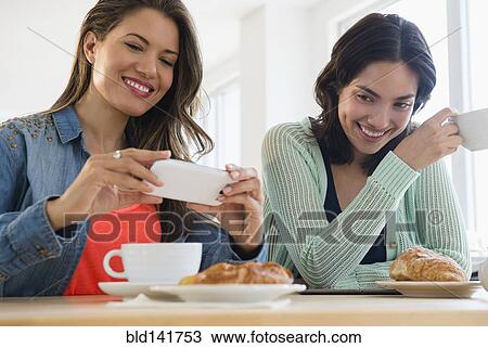 Hispanic women taking cell phone photograph of breakfast View Large Photo Image Stock Image - Hispanic women taking cell phone photograph of breakfast. Fotosearch