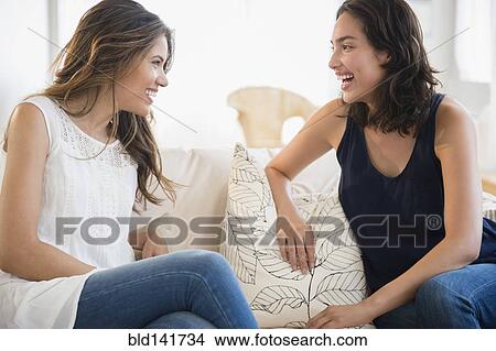 Picture - Hispanic women talking on sofa. Fotosearch
