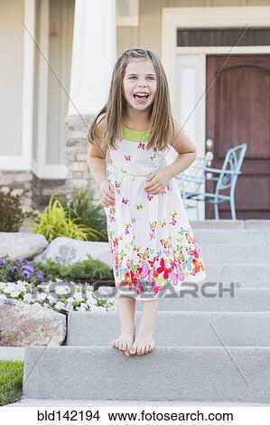 Laughing Caucasian girl standing on front stoop View Large Photo Image Picture - Laughing Caucasian girl standing on front stoop. Fotosearch