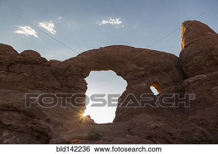 Stock Photograph - Low angle view of Turret Arch rock formation under blue sky, Arches National Park, Utah, United States. Fotosearch