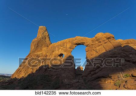 Stock Photography - Low angle view of Turret Arch rock formation under blue sky, Arches National Park, Utah, United States. Fotosearch