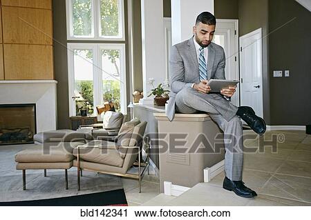 Stock Image - Middle Eastern businessman using digital tablet at home. Fotosearch