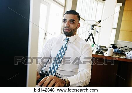 Middle Eastern businessman working at computer in office View Large Photo Image Stock Photo - Middle Eastern businessman working at computer in office. Fotosearch