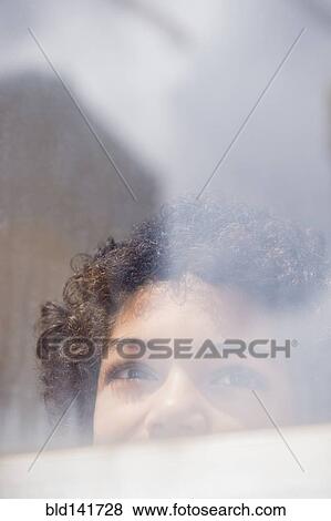 Stock Photo - Mixed race boy looking out window. Fotosearch