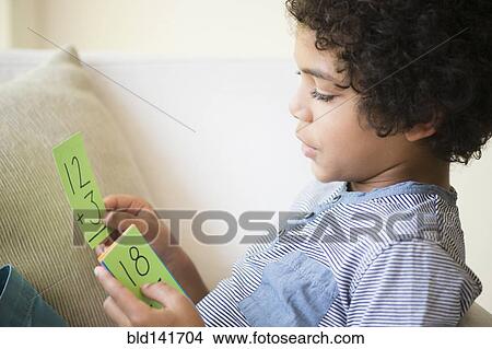 Picture - Mixed race boy using flash cards to study math. Fotosearch