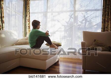 Mixed race girl looking out living room window View Large Photo Image Stock Image - Mixed race girl looking out living room window. Fotosearch