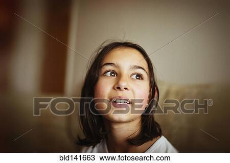 Stock Image - Mixed race girl looking up. Fotosearch
