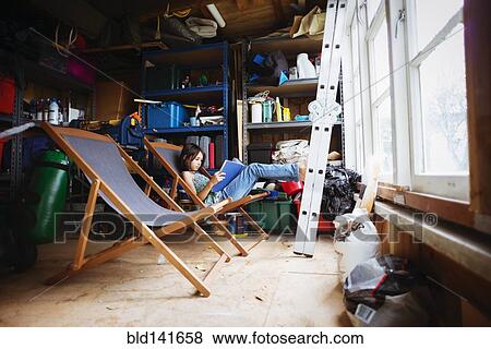 Mixed race girl reading in lawn chair in shed View Large Photo Image Stock Photo - Mixed race girl reading in lawn chair in shed. Fotosearch