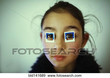 Stock Photo - Mixed race girl wearing stickers on eyes. Fotosearch