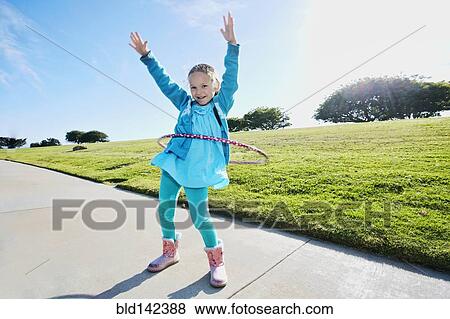 Stock Photo - Mixed race spinning plastic ring on sidewalk. Fotosearch