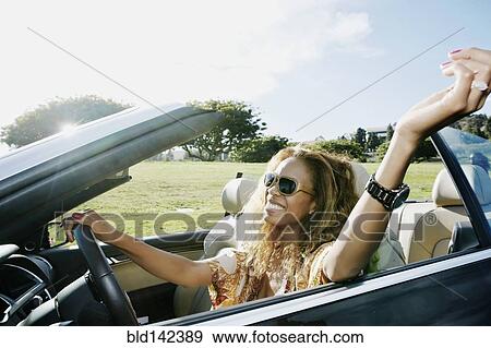 Mixed race woman driving convertible View Large Photo Image Stock Photo - Mixed race woman driving convertible. Fotosearch