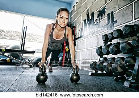 Stock Photograph - Mixed race woman exercising in gym. Fotosearch