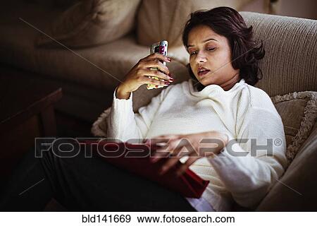 Mixed race woman talking on cell phone and using digital tablet View Large Photo Image Stock Photo - Mixed race woman talking on cell phone and using digital tablet. Fotosearch