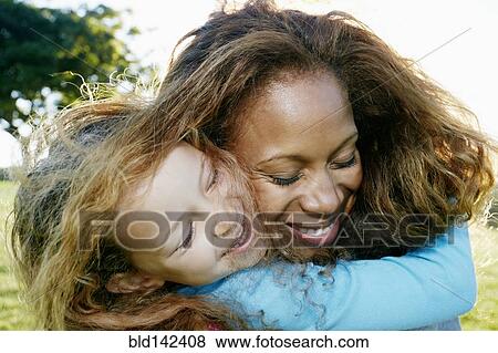 Stock Photo - Mother and daughter hugging outdoors. Fotosearch