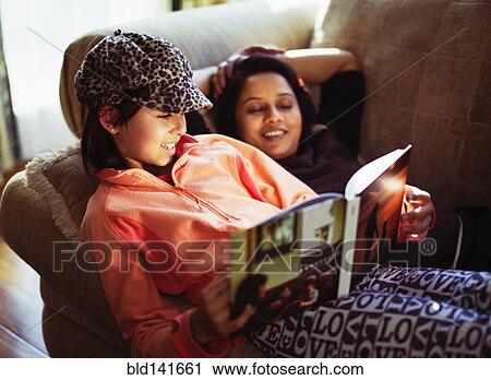 Mother and daughter reading book on sofa View Large Photo Image Stock Image - Mother and daughter reading book on sofa. Fotosearch