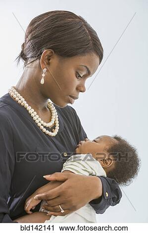 Stock Image - Mother cradling baby son. Fotosearch