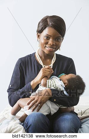 Stock Photo - Mother cradling baby son. Fotosearch