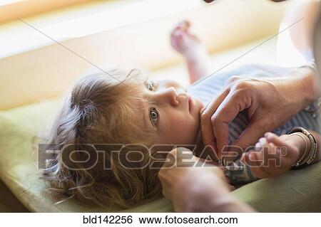 Mother dressing baby boy on changing table View Large Photo Image Stock Photograph - Mother dressing baby boy on changing table. Fotosearch